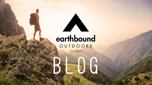 Person standing on a mountain peak, showcasing nature for Earthbound Outdoors blog about national parks.