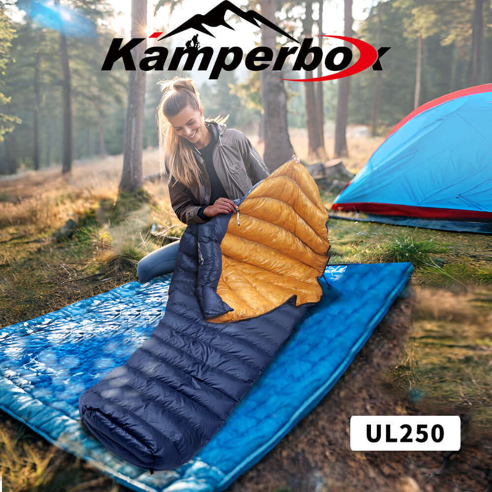 Woman using UL250 UltraLight Down Sleeping Bag outdoors with camping gear in forest.